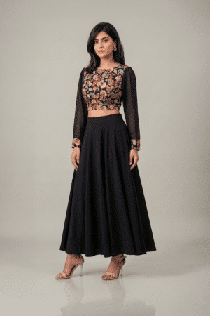 Woman wearing a black floral embroidered dress with sheer sleeves and a flowing flared skirt