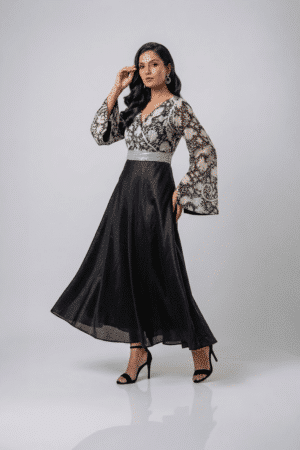 Woman wearing a black gown with a monochrome printed wrap bodice, flared kimono sleeves and a flowing maxi skirt