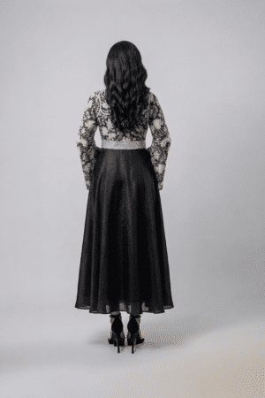 Woman wearing a black gown with a monochrome printed wrap bodice, flared kimono sleeves and a flowing maxi skirt