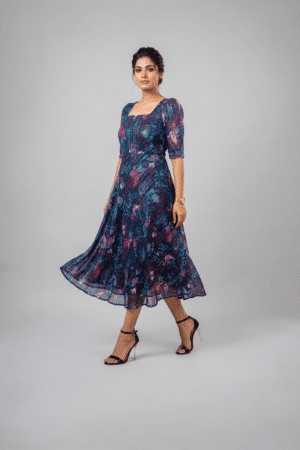 Woman wearing a navy blue floral midi dress with a square neckline, puff sleeves and an A-line silhouette