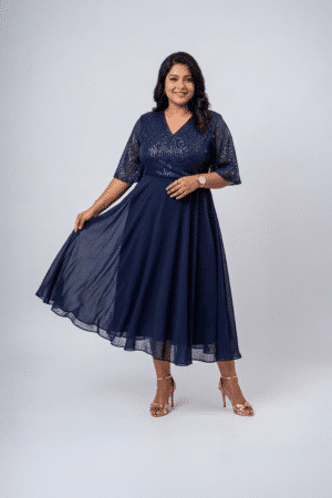 Woman wearing a midnight navy sequin gown with a wrap V-neckline, elbow-length sleeves and a flowing A-line skirt