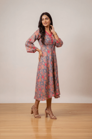 Woman wearing a grey floral print midi dress with a V-neckline, three-quarter bell sleeves and a flared silhouette