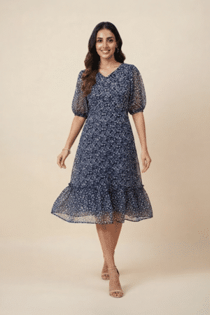 Woman wearing a navy blue floral ruffle midi dress with a V-neckline and sheer puff sleeves