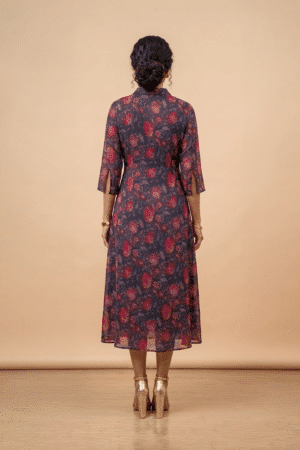 Woman wearing a blue floral shirt dress with three-quarter sleeves and a flared midi silhouette