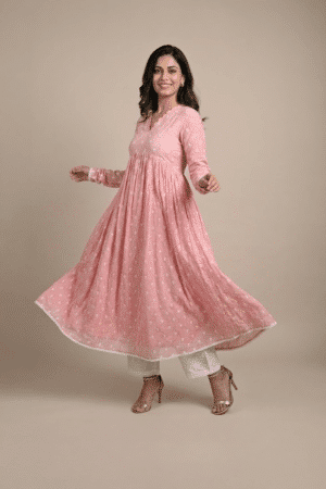 Woman wearing a dusty pink embroidered Anarkali with a scalloped V-neckline, long sleeves and white pants