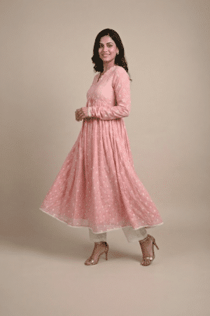 Woman wearing a dusty pink embroidered Anarkali with a scalloped V-neckline, long sleeves and white pants