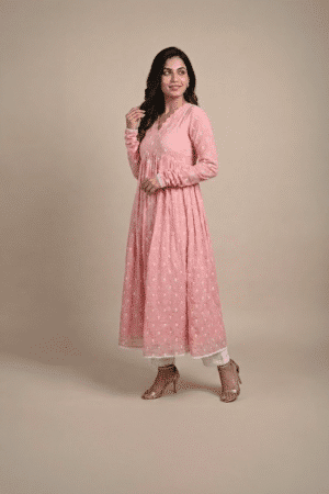 Woman wearing a dusty pink embroidered Anarkali with a scalloped V-neckline, long sleeves and white pants