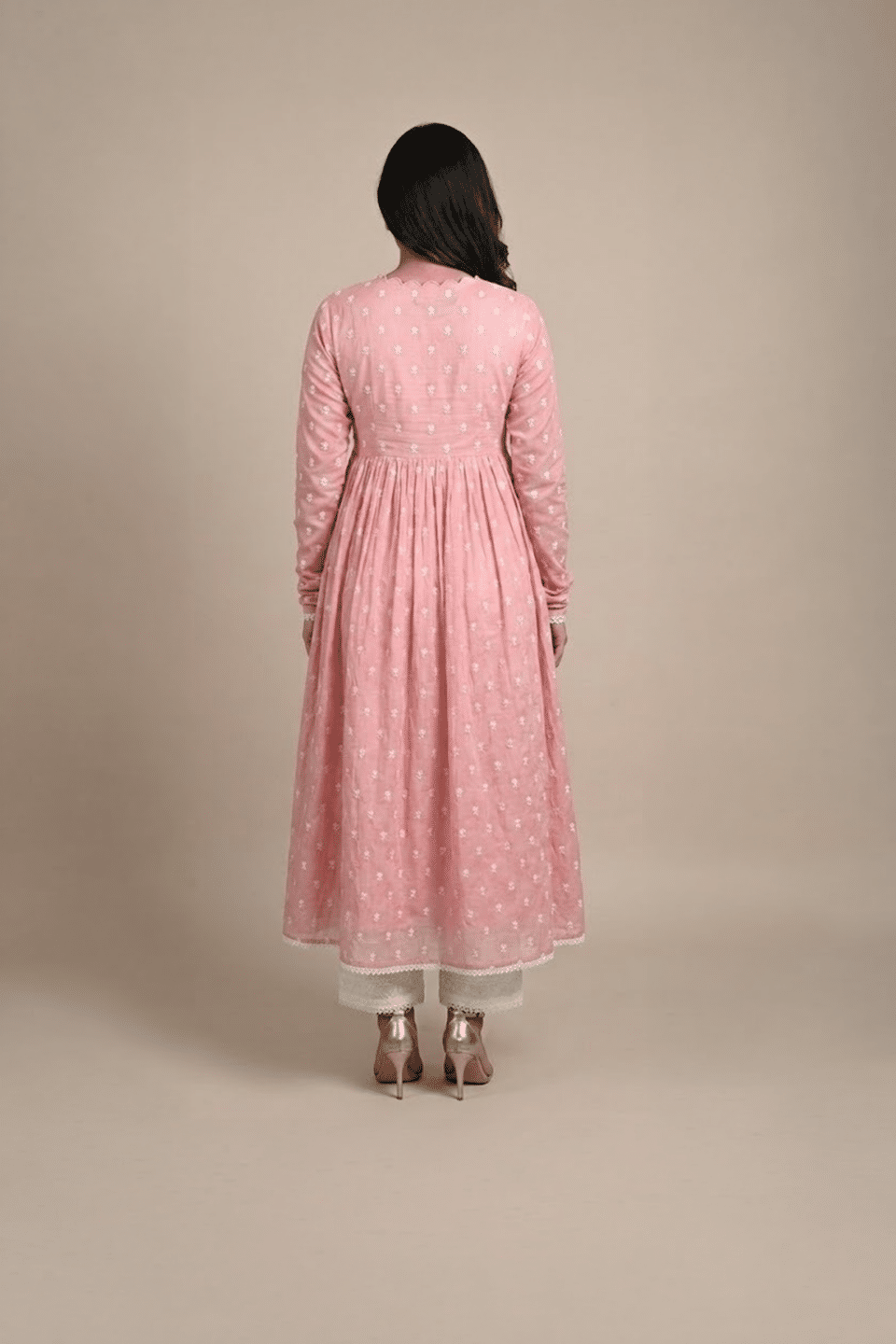 Woman wearing a dusty pink embroidered Anarkali with a scalloped V-neckline, long sleeves and white pants