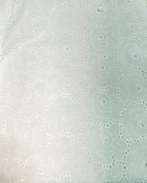 woman wearing a white cotton eyelet shirt dress with three quarter sleeves and waist tie