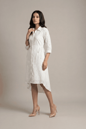woman wearing a white cotton eyelet shirt dress with three quarter sleeves and waist tie
