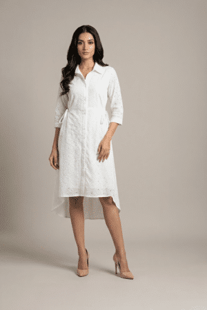 woman wearing a white cotton eyelet shirt dress with three quarter sleeves and waist tie