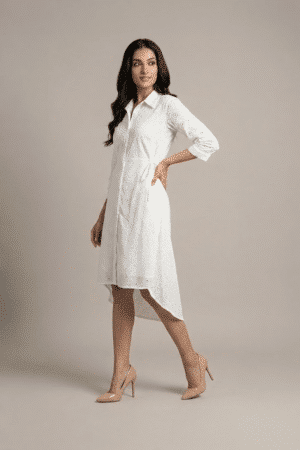 woman wearing a white cotton eyelet shirt dress with three quarter sleeves and waist tie