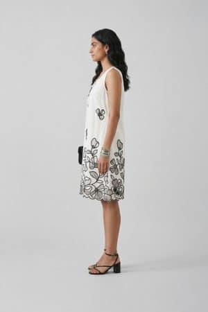 Ivory sleeveless A-line dress with black floral embroidery, side view